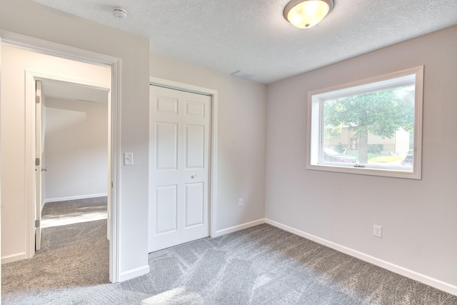 1414 5th Ave SW, Rochester, MN 55902 - unfurnished bedroom with carpet, a closet, a textured ceiling, and baseboards