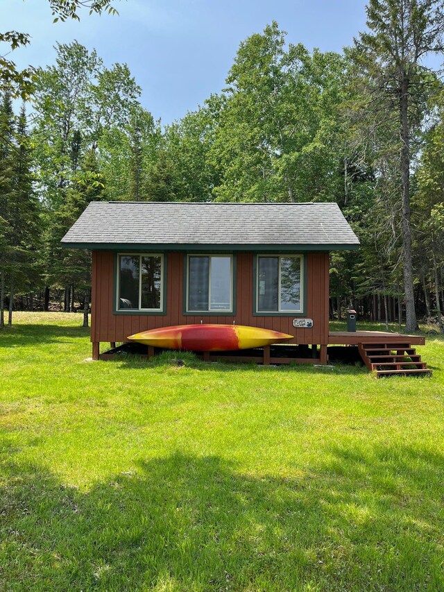 1760 Grindstone Is, International Falls, MN 56649 - rustic home featuring a shingled roof, board and batten siding, a front yard, and a wooden deck