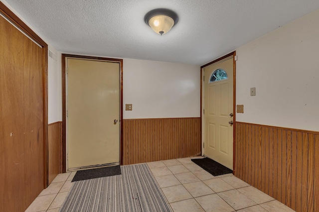 3566 State Highway 210, Baxter, MN 56425 - entrance foyer featuring wainscoting, a textured ceiling, wooden walls, and light tile patterned floors
