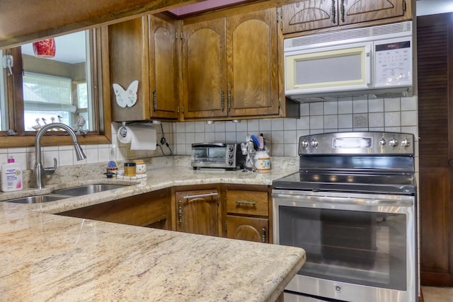 5225 217th St N, Forest Lake, MN 55025 - kitchen with stainless steel electric stove, white microwave, a sink, and brown cabinets