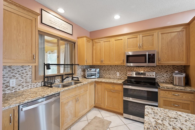 26722 Rabbit Trl, Stanford Twp, MN 55398 - kitchen with appliances with stainless steel finishes, light tile patterned flooring, tasteful backsplash, light stone counters, and a textured ceiling