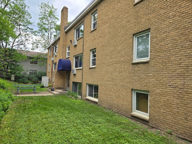 656 Ashland Ave Unit 11, Saint Paul, MN 55104 - back of property with a chimney, a yard, and brick siding