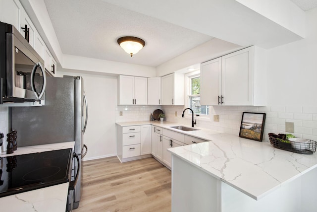 1173 Jefferson St S, Shakopee, MN 55379 - kitchen with stainless steel microwave, a sink, a peninsula, and white cabinets