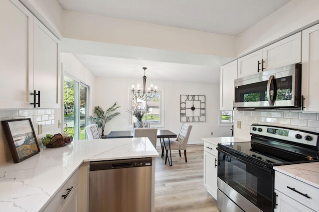 1173 Jefferson St S, Shakopee, MN 55379 - kitchen featuring appliances with stainless steel finishes, a chandelier, white cabinets, and decorative backsplash