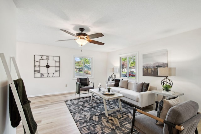 1173 Jefferson St S, Shakopee, MN 55379 - living room featuring ceiling fan, light wood-style floors, baseboards, and a textured ceiling