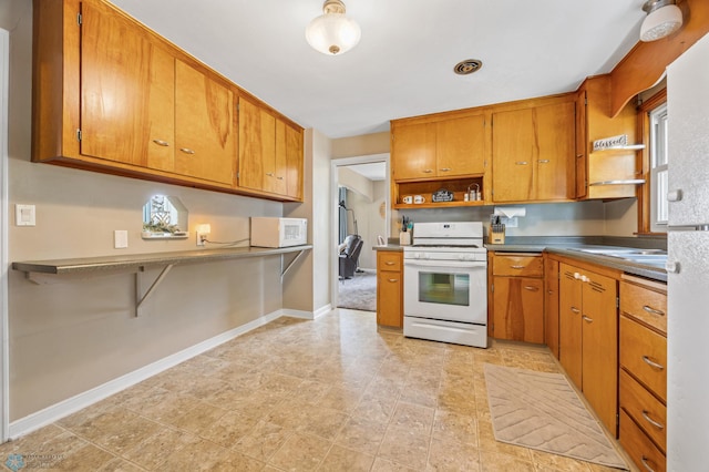 1514 2nd St N, Fargo, ND 58102 - kitchen featuring white appliances, open shelves, brown cabinets, and baseboards