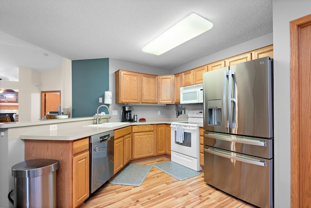 4645 Eagle Ridge Ln, Monticello, MN 55362 - kitchen with stainless steel appliances, a sink, light wood finished floors, a peninsula, and light countertops