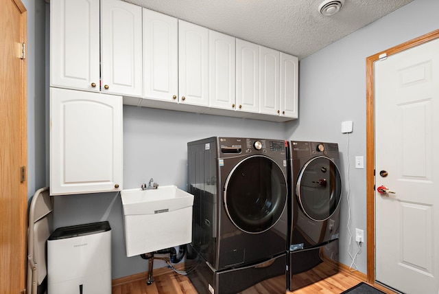 4645 Eagle Ridge Ln, Monticello, MN 55362 - laundry room featuring cabinet space, washing machine and dryer, wood finished floors, and a textured ceiling