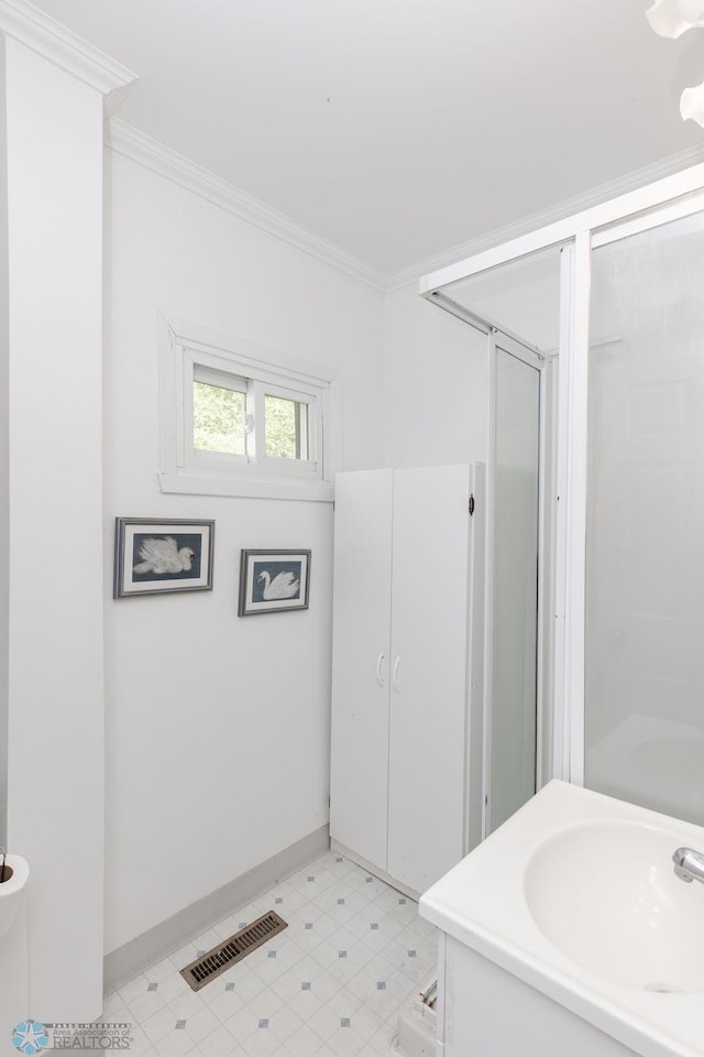 425 12th Ave S, Fargo, ND 58103 - full bathroom with a stall shower, baseboards, crown molding, a sink, and tile patterned floors
