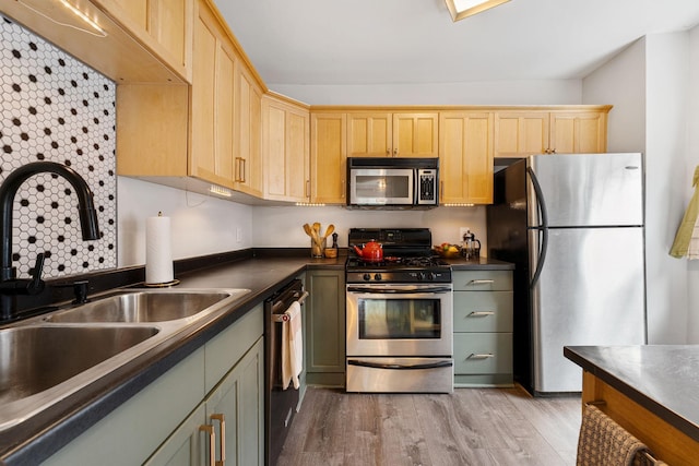 3409 Emerson Ave S Unit 4, Minneapolis, MN 55408 - kitchen with appliances with stainless steel finishes, a sink, dark countertops, light wood-style floors, and light brown cabinetry