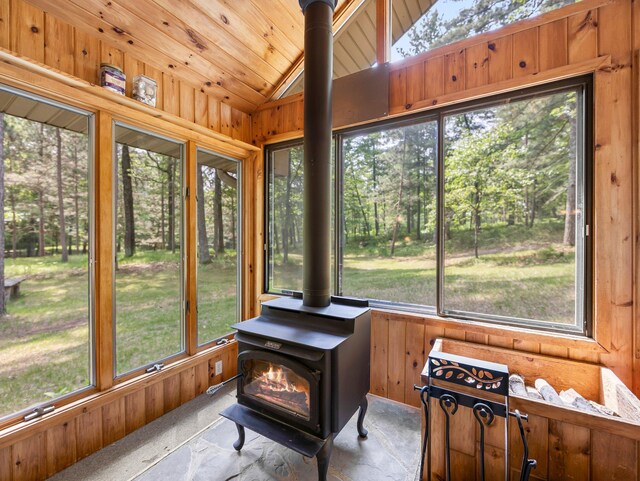 3709 Half Moon Cir, Jackson Twp, WI 54830 - sunroom / solarium with lofted ceiling, a wood stove, plenty of natural light, and wood walls