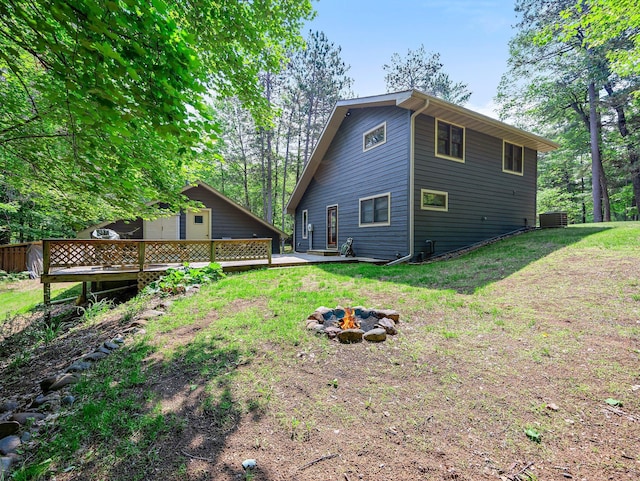3709 Half Moon Cir, Jackson Twp, WI 54830 - rear view of property featuring a wooden deck, a fire pit, and a yard