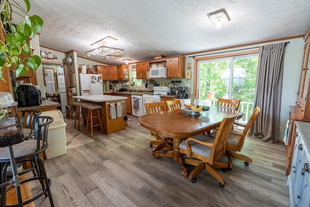 N1024 385th St, Maiden Rock, WI 54750 - dining room featuring a textured ceiling, ornamental molding, light wood finished floors, and vaulted ceiling