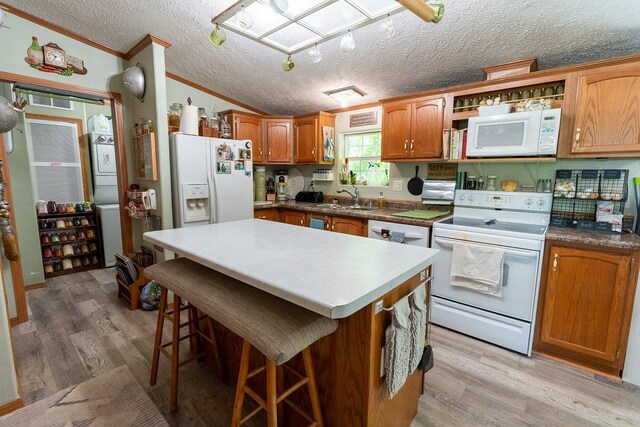 N1024 385th St, Maiden Rock, WI 54750 - kitchen with white appliances, a sink, ornamental molding, lofted ceiling, and light wood finished floors