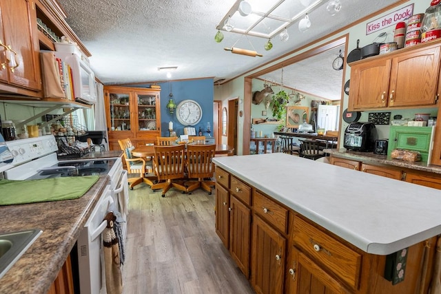 N1024 385th St, Maiden Rock, WI 54750 - kitchen featuring a textured ceiling, white appliances, lofted ceiling, brown cabinets, and light wood finished floors