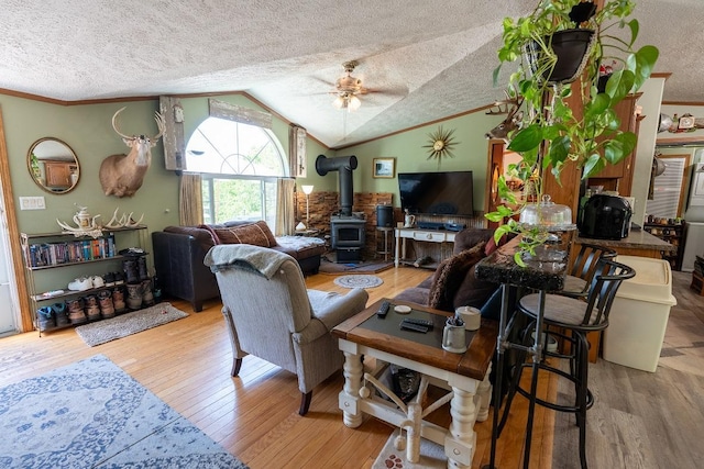 N1024 385th St, Maiden Rock, WI 54750 - living area with a wood stove, a ceiling fan, wood finished floors, lofted ceiling, and a textured ceiling