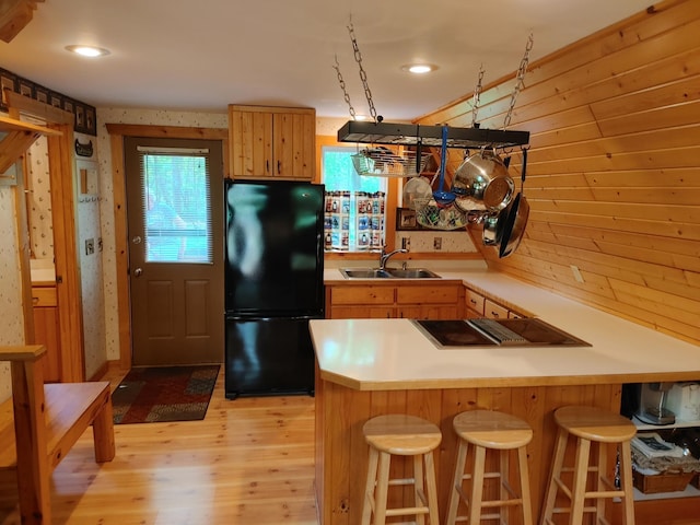 76683 Long Lake Rd, Kettle River Twp, MN 55795 - kitchen with freestanding refrigerator, a sink, stovetop, light wood-style flooring, and a breakfast bar area