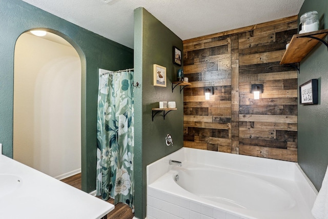 1104 Foede Cir, Montrose, MN 55363 - bathroom with wooden walls, a garden tub, vanity, a shower with shower curtain, and a textured wall