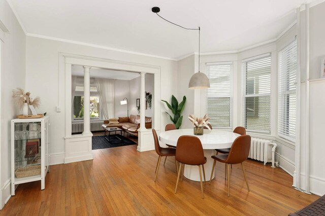 681 Dayton Ave, Saint Paul, MN 55104 - dining room with radiator, ornate columns, hardwood / wood-style floors, and ornamental molding
