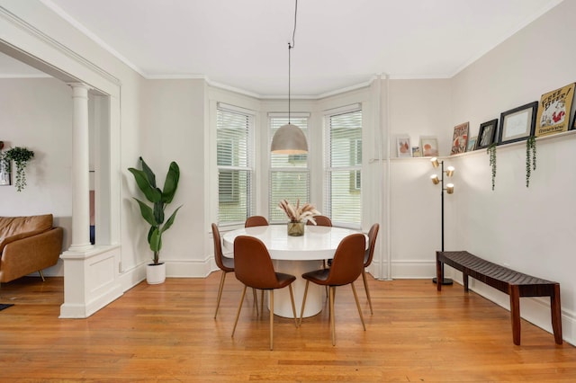 681 Dayton Ave, Saint Paul, MN 55104 - dining area featuring ornate columns, light wood-style floors, crown molding, and baseboards