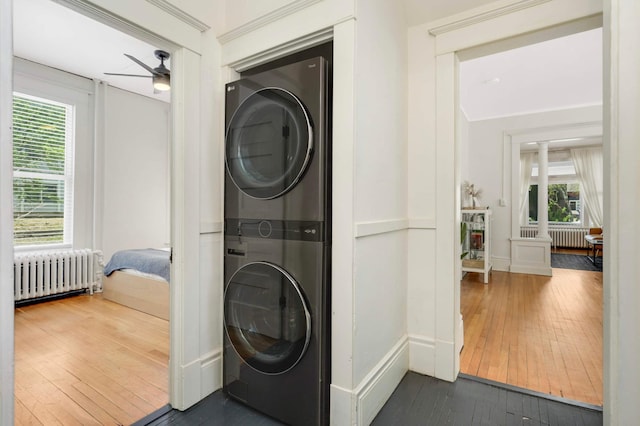681 Dayton Ave, Saint Paul, MN 55104 - laundry room featuring radiator, stacked washer / drying machine, hardwood / wood-style floors, ceiling fan, and plenty of natural light