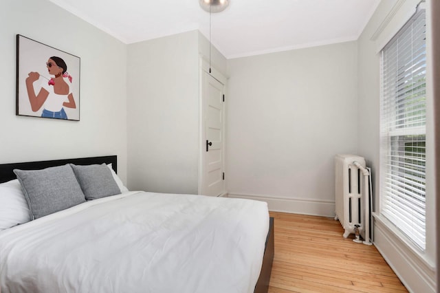 681 Dayton Ave, Saint Paul, MN 55104 - bedroom with radiator, multiple windows, light wood-type flooring, ornamental molding, and baseboards