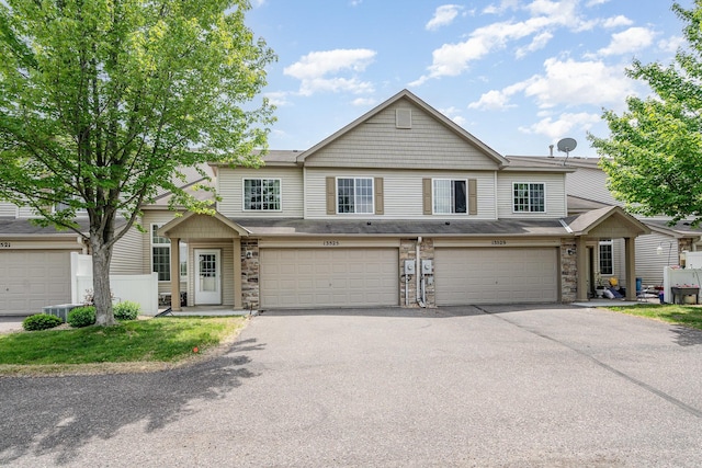 13525 Partridge Cir NW, Andover, MN 55304 - townhome / multi-family property with driveway, stone siding, and a garage