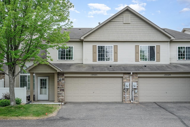 13525 Partridge Cir NW, Andover, MN 55304 - multi unit property with stone siding, an attached garage, driveway, and roof with shingles