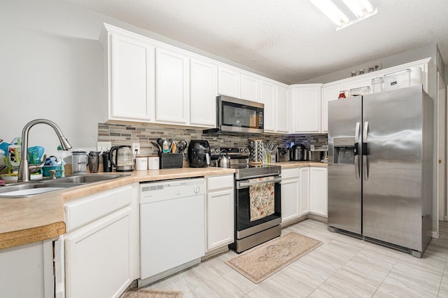 13525 Partridge Cir NW, Andover, MN 55304 - kitchen featuring appliances with stainless steel finishes, a sink, decorative backsplash, light countertops, and a textured ceiling
