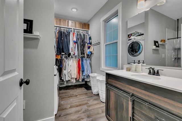 17 Riverside Ave S, Sartell, MN 56377 - bathroom featuring estacked washer and dryer, toilet, vanity, wood finished floors, and a spacious closet