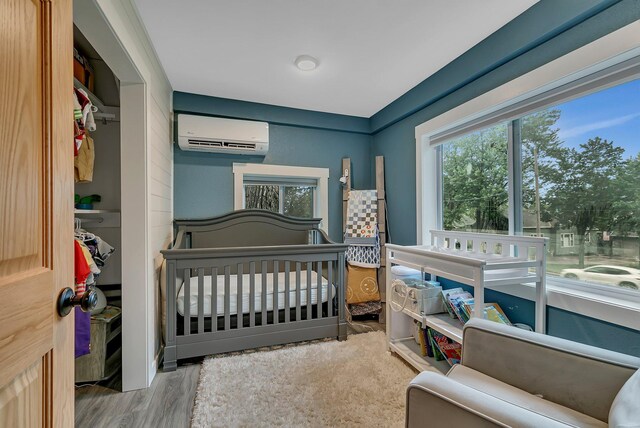 17 Riverside Ave S, Sartell, MN 56377 - bedroom with a wall mounted AC, wood finished floors, and a nursery area