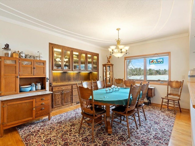 9174 Aloha Ln, Pelican Twp, MN 56472 - dining space featuring a chandelier, light wood-style flooring, and crown molding