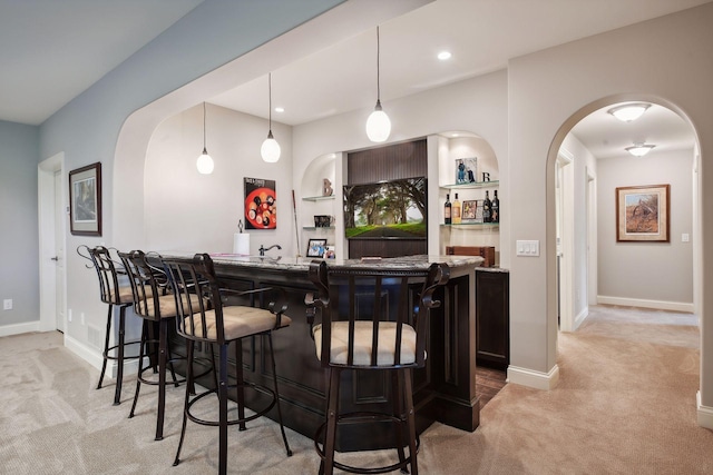 749 Fairway Dr, Medina, MN 55340 - indoor wet bar featuring light colored carpet, baseboards, arched walkways, and pendant lighting