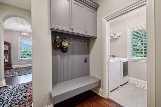 749 Fairway Dr, Medina, MN 55340 - mudroom with washing machine and dryer, baseboards, arched walkways, and wood finished floors