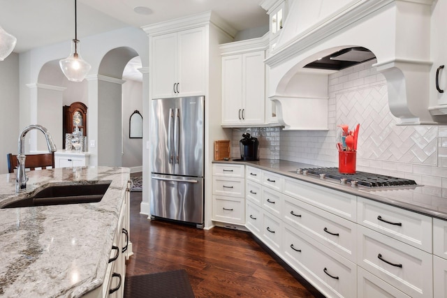 749 Fairway Dr, Medina, MN 55340 - kitchen with appliances with stainless steel finishes, a sink, decorative columns, white cabinets, and arched walkways