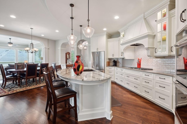 749 Fairway Dr, Medina, MN 55340 - kitchen featuring appliances with stainless steel finishes, arched walkways, decorative backsplash, white cabinets, and recessed lighting