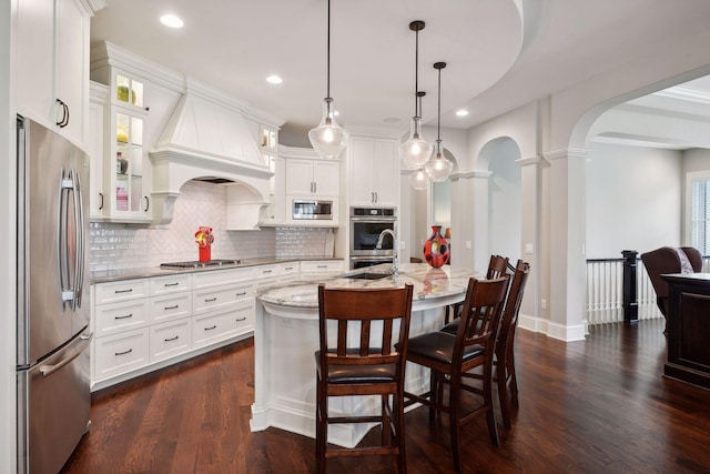 749 Fairway Dr, Medina, MN 55340 - kitchen featuring appliances with stainless steel finishes, arched walkways, backsplash, light stone countertops, and decorative columns
