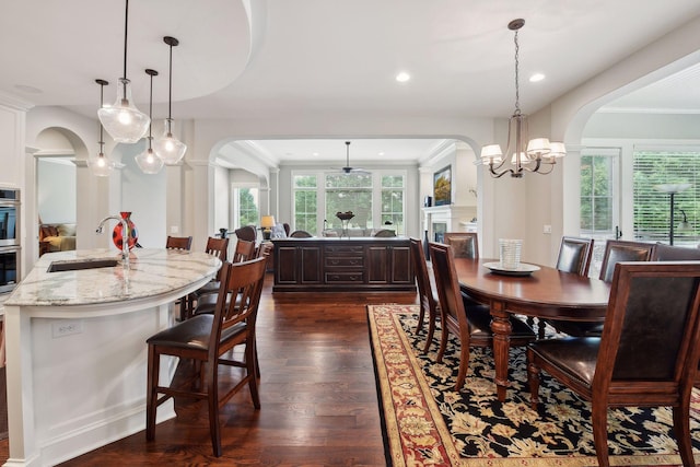749 Fairway Dr, Medina, MN 55340 - dining room with arched walkways, dark wood finished floors, a fireplace, crown molding, and recessed lighting