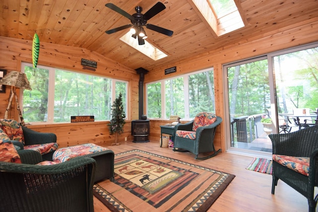 27625 Clear Sky Rd, Jackson Twp, WI 54893 - living area with a skylight, vaulted ceiling, wood walls, a wood stove, and a ceiling fan