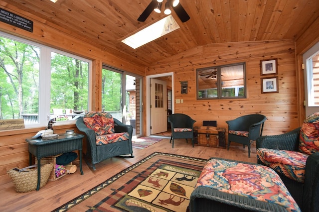 27625 Clear Sky Rd, Jackson Twp, WI 54893 - living area featuring a skylight, vaulted ceiling, a ceiling fan, wood finished floors, and wooden walls