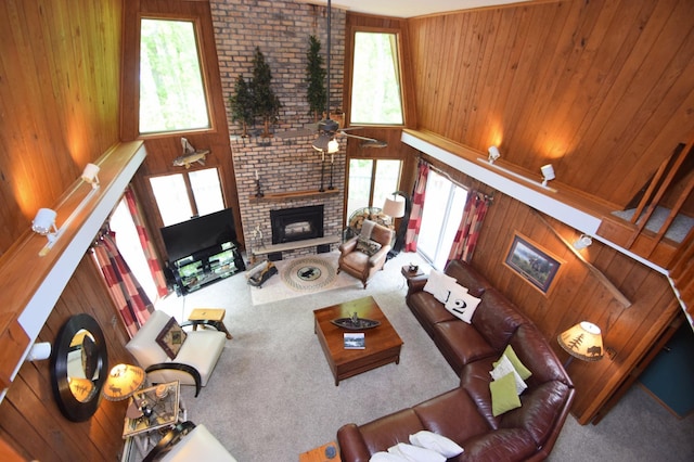 27625 Clear Sky Rd, Jackson Twp, WI 54893 - living area featuring a fireplace, carpet flooring, wood walls, and healthy amount of natural light