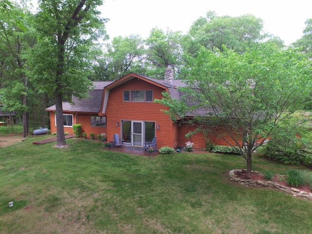 27625 Clear Sky Rd, Jackson Twp, WI 54893 - rear view of property with a gambrel roof, a lawn, a shingled roof, and a chimney