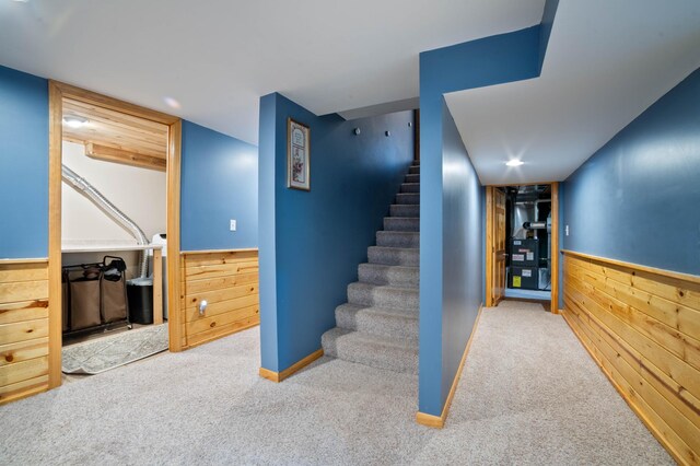 1609 Doddridge Ave, Cloquet, MN 55720 - staircase featuring carpet floors, wooden walls, and wainscoting