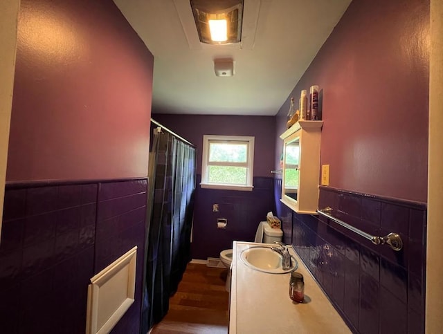 312 1st St NE, Sebeka, MN 56477 - full bath featuring toilet, vanity, wood finished floors, a shower with curtain, and tile walls