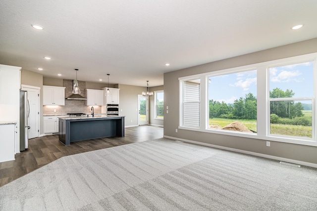 20610 Redwood St NW, Oak Grove, MN 55011 - kitchen with a chandelier, dark wood-style floors, wall chimney exhaust hood, appliances with stainless steel finishes, and open floor plan