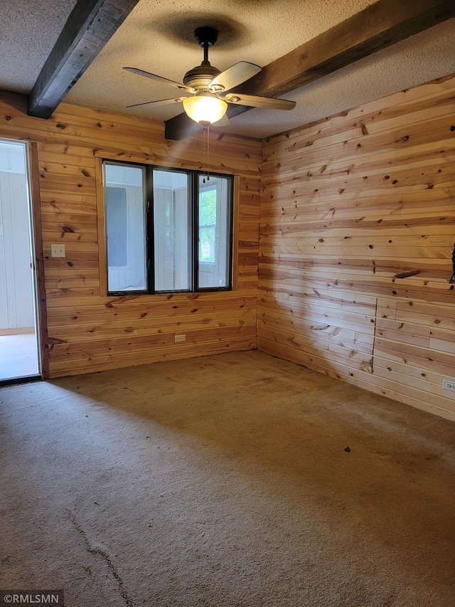 203 Ann Ave E, Clarissa, MN 56440 - spare room with a textured ceiling, beam ceiling, wood walls, a ceiling fan, and carpet floors