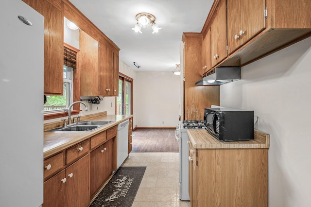 800 82nd Ave N, Brooklyn Park, MN 55444 - kitchen featuring white appliances, under cabinet range hood, light countertops, and brown cabinets