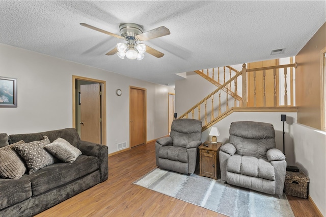 861 Lake Susan Dr, Chanhassen, MN 55317 - living area featuring wood finished floors, ceiling fan, stairway, and a textured ceiling