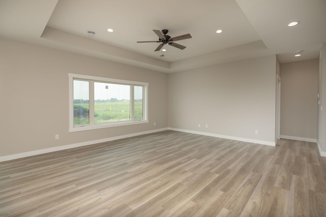 1202 15th St NE, Kasson, MN 55944 - spare room featuring recessed lighting, ceiling fan, light wood-style floors, a tray ceiling, and baseboards