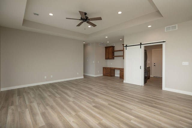 1202 15th St NE, Kasson, MN 55944 - unfurnished living room with a tray ceiling, recessed lighting, a ceiling fan, baseboards, and light wood-style flooring